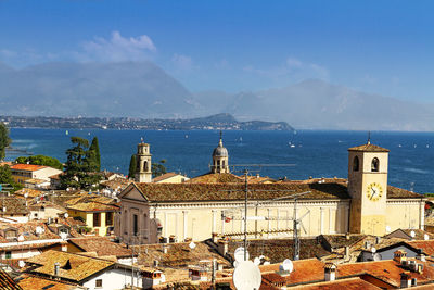 High angle view of townscape by lake against sky