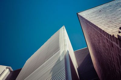 Low angle view of office building against blue sky