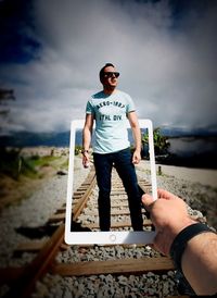 Full length of man standing on street against sky