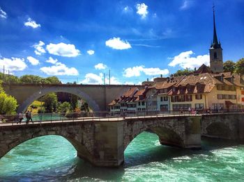 Arch bridge over river against sky