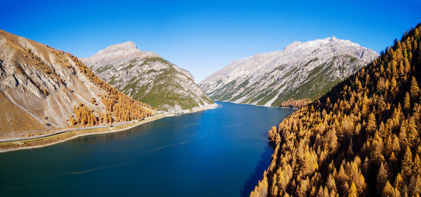 Panoramic view of lake and mountains against clear blue sky