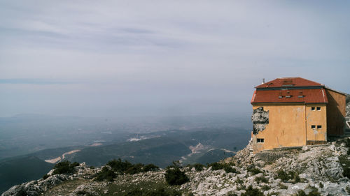 Building on mountain against sky