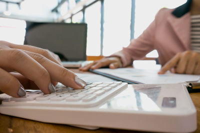 Midsection of man using laptop on table