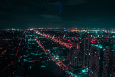 High angle view of city lit up at night