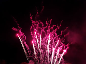 Low angle view of firework display against sky at night