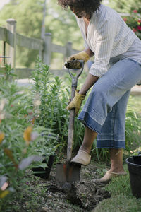 Woman shoveling soil in garden