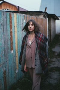 Portrait of woman standing against wall