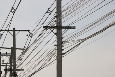 Low angle view of electricity pylon against clear sky