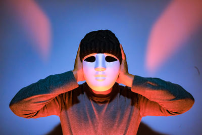 Man wearing mask against wall