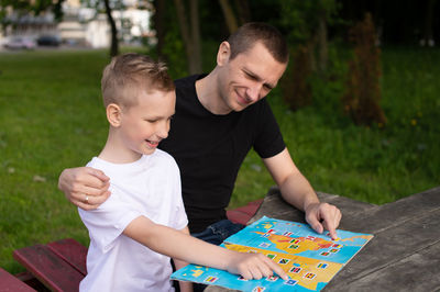 Side view of boy playing with toy on field