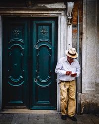 Man standing against closed door of building