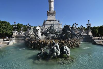 Fountain against clear blue sky