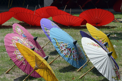 Multi colored paper umbrella on field