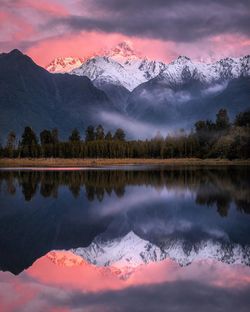 Scenic view of lake and mountains against sky during winter