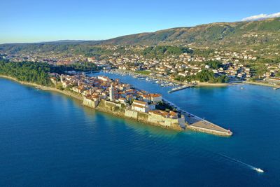 High angle view of sea by city against sky