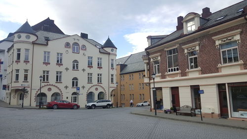 Cars on street in city against sky