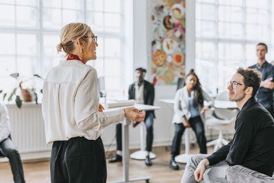 Mature businesswoman discussing with colleagues in meeting at office