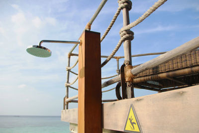 Low angle view of basketball hoop by sea against sky