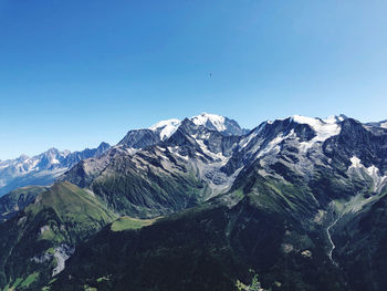 Scenic view of snowcapped mountains against clear blue sky