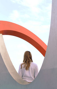 Rear view of woman standing against sky