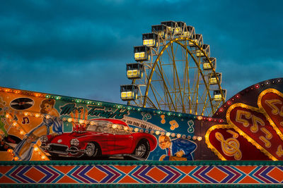 Low angle view of illuminated ferris wheel against sky