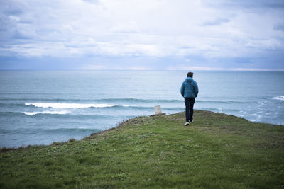 Rear view of woman looking at sea against sky