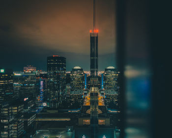 Illuminated cityscape against sky at night