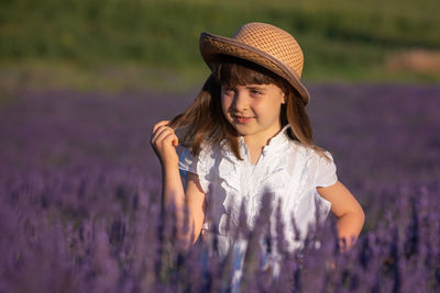 Woman standing by purple flower on field