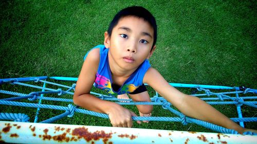 Portrait of cute boy playing on jungle gym