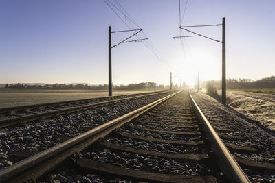 Railway tracks on a winter morning, frosted nature and bright sun. german rail infrastructure