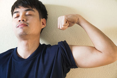 Portrait of young man against wall