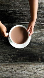 Directly above shot of person holding tea cup on table