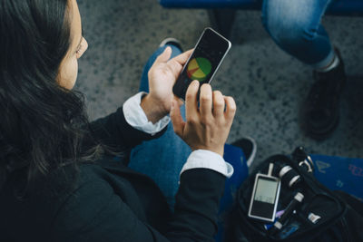 Woman checking blood sugar level and using mobile phone in train