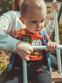 Rear view of boy looking at mobile phone