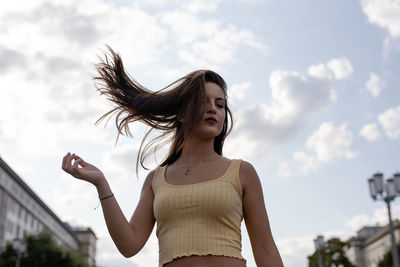 Woman tossing hair while standing in city