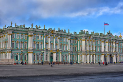 Facade of building in city against cloudy sky