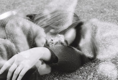 Double exposure of woman lying on floor with flower petal