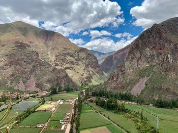 Panoramic view of field and mountains against sky