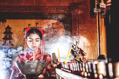 Teenage girl praying at temple