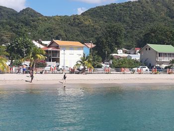 Buildings by sea against mountain