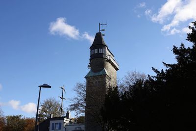 Low angle view of tower amidst buildings against sky