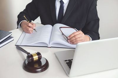 Midsection of lawyer doing paperwork in courtroom