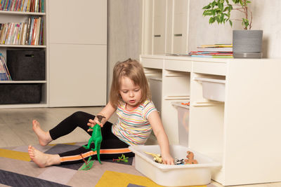 Child playing on the floor in dinosaurs in the room. development in the game. 
