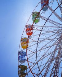 Low angle view of ferris wheel against clear blue sky