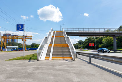 A pedestrian overpass across a busy city highway provides access from a microdistrict.