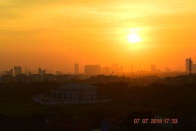 Silhouette buildings against sky during sunset