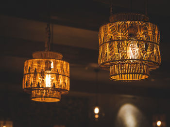 Low angle view of illuminated pendant lights hanging from ceiling