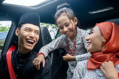 Portrait of smiling young woman sitting in car