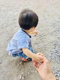 High angle view of cute boy holding hands on land