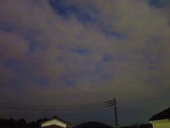 Low angle view of silhouette electricity pylon against sky